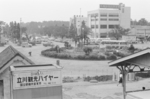 国立駅ホームより南口の駅前広場を撮影した1枚。国立駅南口の駅前広場の撮影ポイントだったようで、昭和初期頃の写真にも同じポイントから撮影したとみられるものが見うけられます。中央の円形公園の奥に写っている多摩信用金庫のビルは、1962（昭和37）年1月に完成したものです。