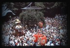 武蔵総社の由緒を持つ、大國魂神社例大祭のクライマックスは、5月5日。８基の神輿が境内から御旅所に渡御し、翌朝還御する。この祭は、夜に神輿が発御するところから「くらやみ祭」と呼ばれている。戦後すぐは午後9時からで、それ以前はさらに遅い時間からの発御だった。しかし、昭和36年（1961）、暴動を避ける措置として、発御時間が早まり、まだ暗くない午後4時からとなっていた。写真はまだ明るい境内からの三之宮神輿発御の様子。平成14年（2002）に午後6時発御と繰り下げられたため、明るい時間帯にこうした姿を見ることはできなくなっている。