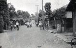 ここは昭和20年代当時の羽村（当時は西多摩村）のメインストリートです。場所は現在の羽村駅の西口側から段丘を下った所で、寺坂という坂道の下にあり、「銀座通り」とも呼ばれていました。