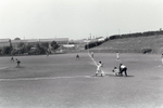 昭和24年（1949）に開設された牛浜町営グラウンド（現福生野球場）で行われた野球の様子です。<br />
この一帯は連合軍の砂利採掘場があった段丘で、採掘によってできた段丘崖を利用してスタンドが造られています。<br />
