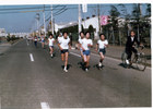 武蔵野台の産業道路をゼッケンをつけた子どもたちが走っています。
