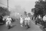 昭和33（1958）年5月21日午後、甲州街道を疾走する第3回アジア競技大会の聖火リレーを収めた1枚。当時の町報に拠ると、谷保天満宮から西に向かって、町長・副議長・教育長の3名が正走者として甲州街道を継走したようです。